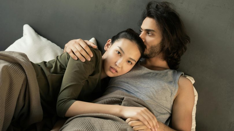 A couple lying together in an intimate embrace, symbolizing support and hope in their fertility journey.