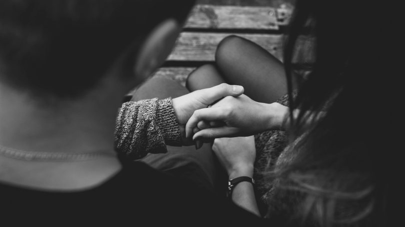 Black and white image of a couple holding hands