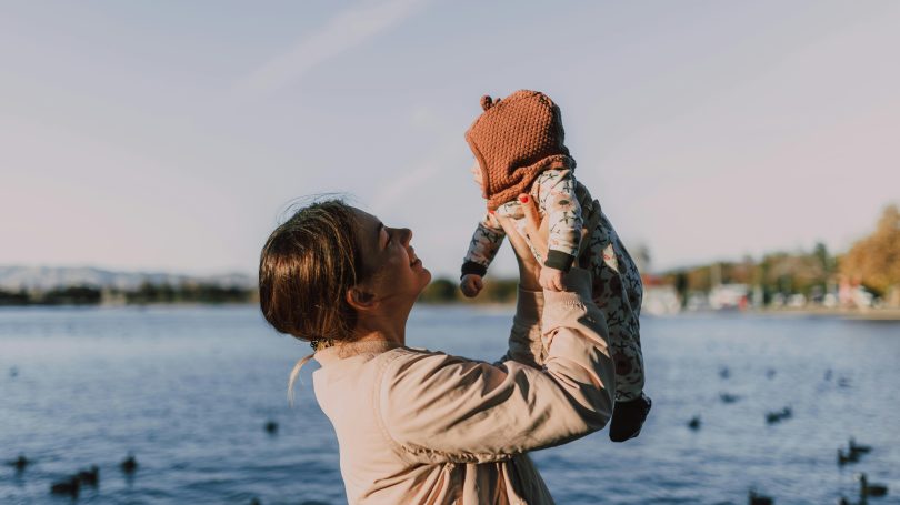 Mother holding baby at the beach in winter