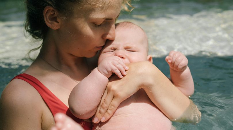 Mother holding baby on the beach